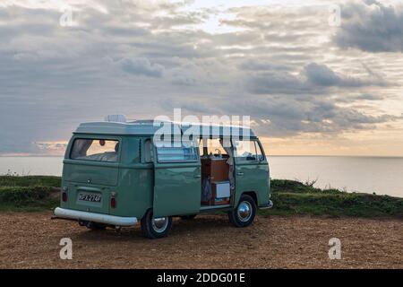 Ein klassischer VW-Wohnmobil, der bei Sonnenuntergang in der Compton Bay auf der Isle of Wight geparkt ist Stockfoto