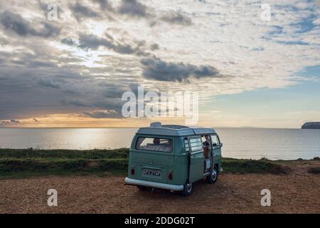 Ein klassischer VW-Wohnmobil, der bei Sonnenuntergang in der Compton Bay auf der Isle of Wight geparkt ist Stockfoto