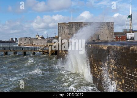 Blick entlang der Küste in Old Portsmouth, Hants, während eines rauen Wintersturms, mit Wellen, die gegen die Ufermauer vor dem Square Tower brechen. Stockfoto