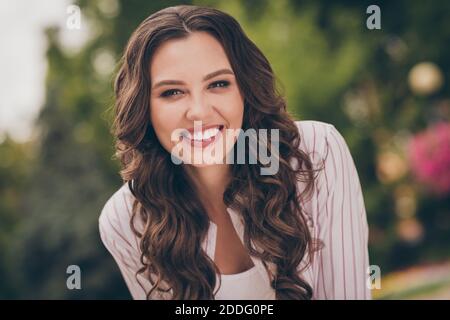 Foto-Porträt der schönen Brünette mit lockigen Haaren lächelnd lachen Im grünen Sommerpark Stockfoto