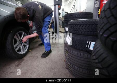 Berlin, Deutschland. November 2020. Ein Mechaniker in einer Autowerkstatt im Bezirk Lichtenberg wechselt ein Fahrzeug von Sommer- auf Winterreifen und zieht die Radschrauben mit einem Drehmomentschlüssel fest. Die Faustregel für einen saisonalen Reifenwechsel lautet: Von A nach O (Allerheiligen bis Ostern). Wer trotz schlechtem Wetter einen Unfall mit Sommerreifen hat, zahlt eine schwere Geldstrafe (Winterreifenanforderung). Winterreifen sind am effektivsten, wenn die Durchschnittstemperatur unter sieben Grad Celsius liegt. Quelle: Wolfgang Kumm/dpa/Alamy Live News Stockfoto