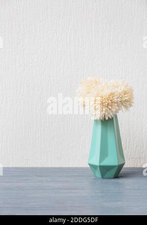 Schöne Vase mit Chrysanthemen auf Tisch vor weißem Hintergrund Stockfoto