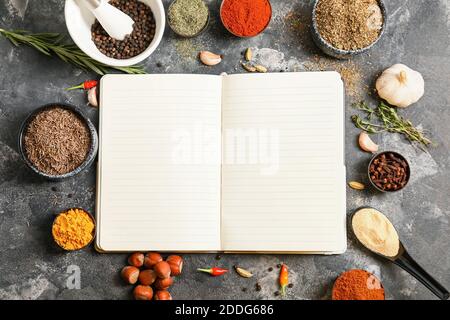 Notizbuch für Rezepte und Gewürze auf grauem Tisch Stockfoto