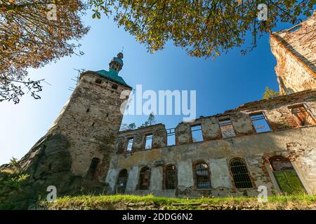 Hartenberg, Tschechische Republik - Oktober 14 2018: Blick auf die ruinierte gotische Burg mit einem von Bäumen umgebenen Turm. Heller sonniger Herbsttag mit blauem Himmel. Stockfoto