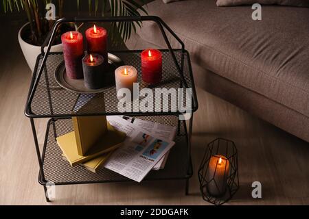 Schöne Duftkerzen auf dem Tisch im dunklen Raum Stockfoto