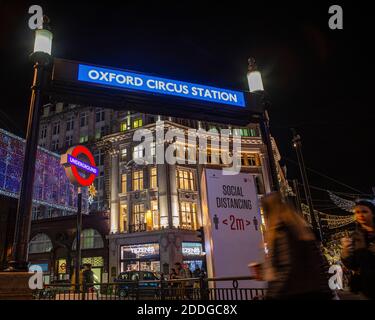 London, Großbritannien - 22. November 2020: Einer der Eingänge zur U-Bahnstation Oxford Circus, abgebildet mit einem sozialen Distanzschild während des Coronavir Stockfoto