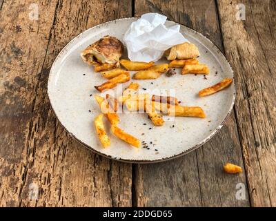 Reste von Burgern und pommes auf dem Teller Holztisch Stockfoto