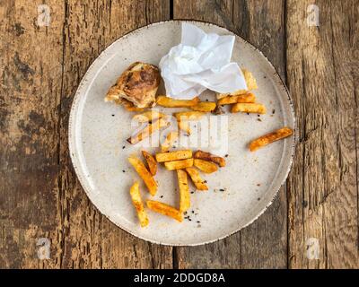 Reste von Burgern und pommes auf dem Teller Holztisch Stockfoto