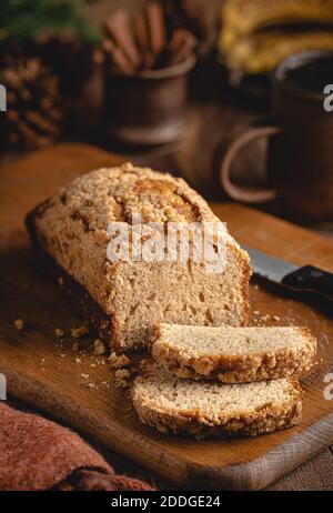 Laib Bananennussbrot in Scheiben geschnitten auf einem rustikalen Holz Schneidebrett Stockfoto