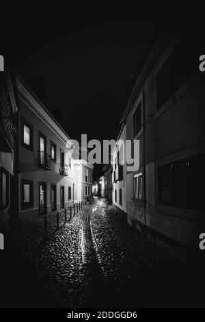 Eine vertikale Graustufenaufnahme der Straßen Portugals eingefangen Während der Nacht Stockfoto