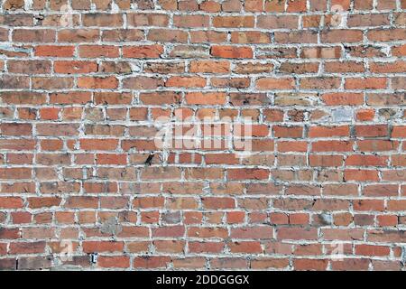 Verlassene alte verwitterte rote Ziegelwand mit tiefen Schatten Und Details als Hintergrund für Website Architektur Präsentation Landschaft Stockfoto