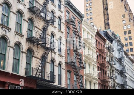 Von unten nach außen von alten schäbigen Wohngebäuden mit Metallleitern in New York Stockfoto