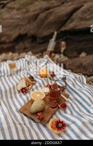 Hoher Winkel von appetitlich sortierte Lebensmittel auf Holz Schneidebrett Arrangiert auf Decke in der Nähe des Flusses für Picknick Stockfoto