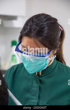 Männlicher Arzt mit Gesichtsmaske und Gesichtsschutz während der Arbeit Stockfoto