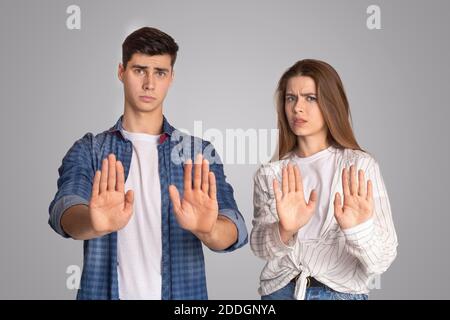 Unzufrieden und verärgert jungen Mann und Frau Gesten und eingezäunt Mit den Händen weg und die Kamera betrachten Stockfoto