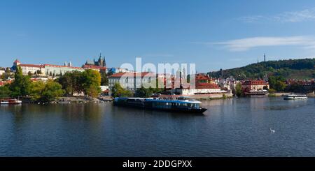 Ausflugsboot auf dem Moldausteg im Herbst. Blick auf Prag. Stockfoto