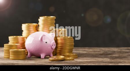 Stapel von Goldmünzen mit Sparschwein auf schwarzem Hintergrund. Stockfoto