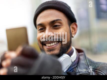 Hübscher junger Mann mit Handy auf der Straße Stockfoto