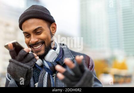 Hübscher junger Mann mit Handy auf der Straße Stockfoto