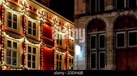 Urban Weihnachten Fassade Dekorationen. Weihnachten Girlande leuchtet auf Fensterhaus. Festliche Beleuchtung der Straßen der Stadt. Neujahrsdekor. Europäischer Jahrgang Stockfoto