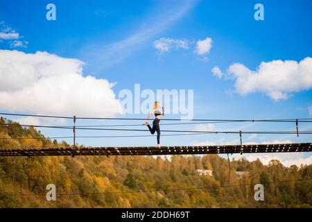Fit Athlet Frau läuft auf Holzbrücke über Berge Fluss. Weibliche Fitness Jogging Workout Wellness Konzept. Stockfoto