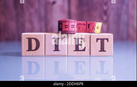 Text DIÄT auf Holz Würfel Blöcke. Die Buchstaben DIÄT auf den Würfeln in schwarzen Buchstaben isoliert auf einer Glasoberfläche geschrieben. DIÄT-Text für Ihr Design. Stockfoto