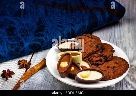 Schokolade mit Mandeln und Haselnüssen auf einem hellen Holztisch mit einem blauen Tuch im Hintergrund. Provenzalischer Stil Stockfoto