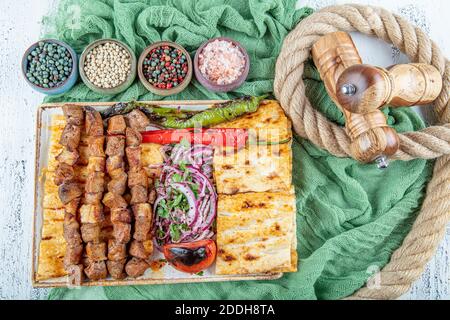 Türkische Küche köstliche Ciger Spieß. Leberspieß, türkischer Ciger Shish Kebab auf kleinem Grill mit Tomaten, lecker, natürlich, Nahaufnahme suchen. Stockfoto