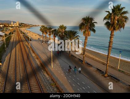 Eisenbahn und Badalona Strand durch das verblassen des Metalls Zaun Stockfoto