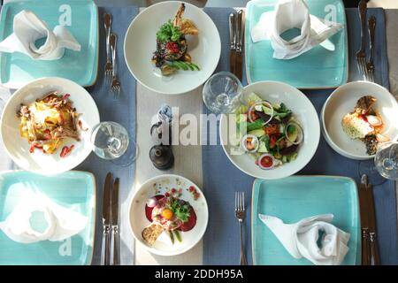 Mittagessen im Restaurant. Blick von oben auf leckere Gerichte sind auf dem Tisch. Wunderschön servierter Tisch für vier Personen in einem Restaurant. Stockfoto