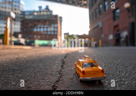 , - 01. Jan 1970: Nahaufnahme eines gelben klassischen Taxi-Modells, das auf der Straße geparkt ist, mit einem abendlichen Blick auf die Brooklyn Bridge aus dem Park Stockfoto