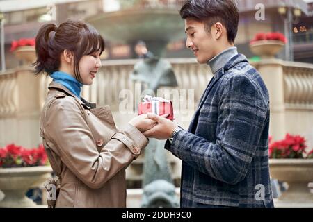 Junge asiatische Mann geben Freundin ein weihnachten oder Geburtstag Geschenk Stockfoto