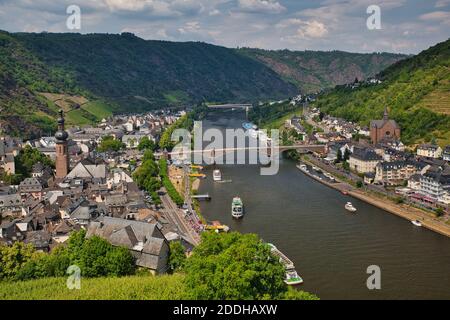 Ein Blick auf den Rhein mit Booten, wo er durch Cochem, Deutschland, mit Brücken und Gebäuden passiert Stockfoto