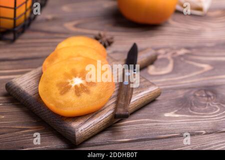 Frisch reife, in Scheiben geschnittene, orangefarbene, juckige Kaki, Nahaufnahme. Stockfoto