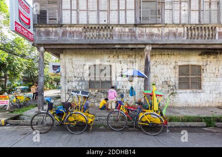 Lokale Pedicabs parken neben einem alten Haus in Ozamiz City, Philippinen Stockfoto