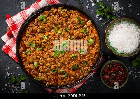 Bolognese steht in Eisenplatte am schwarzen Tisch. Stockfoto