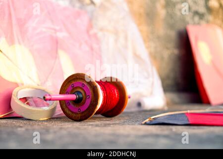 Serie von bunten rot gelben Papier und Holz-Kits platziert In der Nähe fikri charki Spulen mit dor einfachen Faden und gefüllt Manjha Glas abgedeckt Gewinde für die Stockfoto