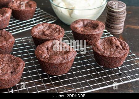 Oreo gefüllte Brownie Cups: Brownie Tassen gefüllt mit einem Sandwich-Cookie und gekrönt mit Zuckerguss auf einem Draht Kühlgestell Stockfoto