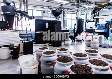 Nahaufnahme von frisch gerösteten Kaffeebohnen in der Nähe der Röstermaschine Stockfoto
