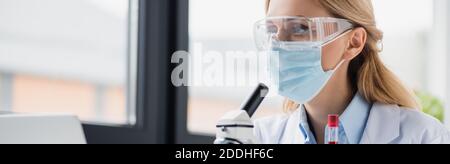 Wissenschaftler in der medizinischen Maske und Brille im Labor, Banner Stockfoto