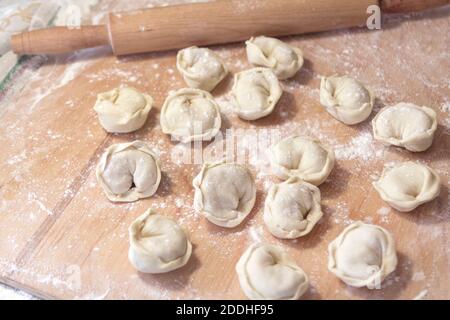 Ungekochte russische Pelmeni auf Holz Schreibtisch Hintergrund hausgemachte Pelmeni Ravioli oder Knödel. Stockfoto