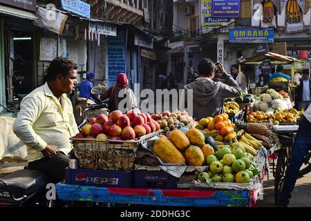 Pushkar, Rajasthan, Indien - Dezember 2016: Indischer Verkäufer, der tropische Früchte (Papaya, Äpfel, Guava, Orangen) vom Verkaufsstand auf der Straße verkauft Stockfoto