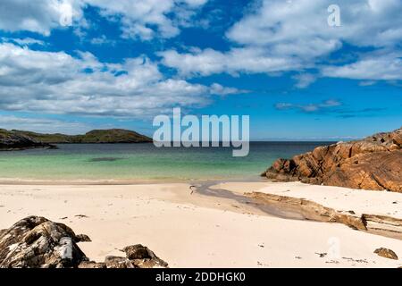 ACHMELVICH BAY LOCHINVER SUTHERLAND SCHOTTLAND EIN KLEINER WEISSER SANDSTRAND UND EIN KLARES BLAUES UND TÜRKISFARBENES MEER Stockfoto