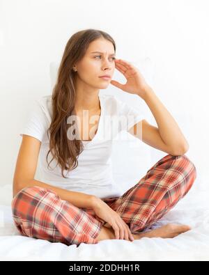 Frau massiert Schläfen des Kopfes wegen Kopfschmerzen nach dem Aufwachen. Migräne Stockfoto