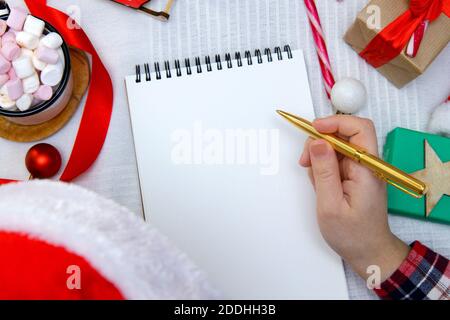 Kind in rotem Hut schreibt Brief an den Weihnachtsmann und nächste Zum Marshmallow und Zuckerrohr Stockfoto