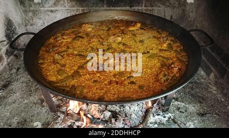Eine Nahaufnahme von Paella in einer großen Schüssel Kochen auf Das Feuer im Freien Stockfoto