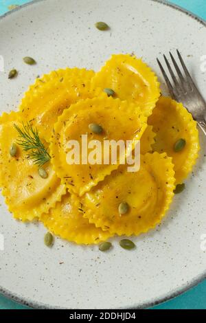 Hausgemachter Kürbis Ravioli mit Butter auf hellem Betongrund. Draufsicht Stockfoto