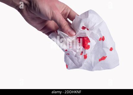 Nasenplatte mit Blut in der Hand. Isolieren auf weißem Hintergrund. Verletzte Hand mit blutigem Taschentuch vor weißem Hintergrund. Stockfoto