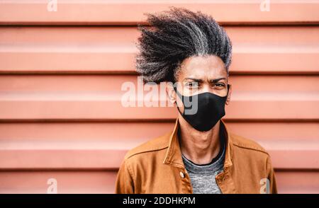 Portrait von afroamerikanischen Kerl trägt schwarze Schutzmaske Gesicht - Neue normale Lifestyle-Konzept mit jungen Mann, die tatsächliche Denkweise Stockfoto