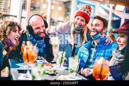 Freunde trinken Cocktail im Open Air Bar Restaurant - Neu Normale Freundschaft Konzept mit glücklichen Gruppe Spaß zusammen tragen Gesichtsmaske Stockfoto